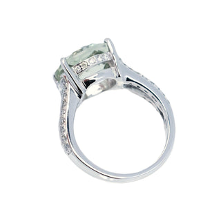 Silver ring with a green gemstone on a white background
