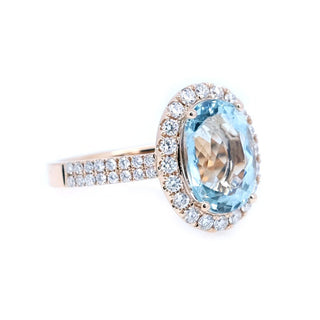 Ring with a large blue gemstone and smaller diamonds on a white background